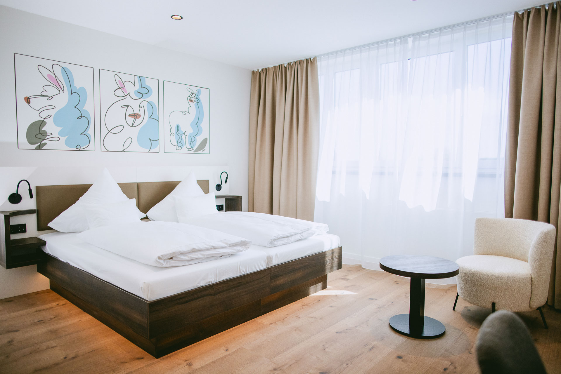 Helles Komfortzimmer mit Doppelbett und Sitzgelegenheit