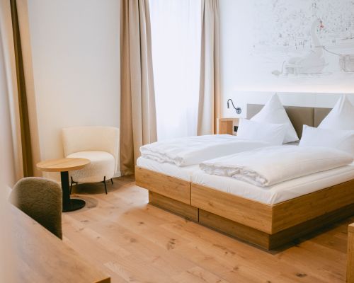 The room offers a pleasant combination of sleeping area and small seating corner.