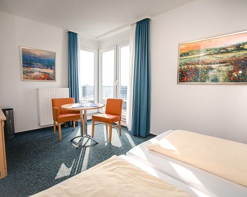 Double room with balcony, seating area and natural daylight