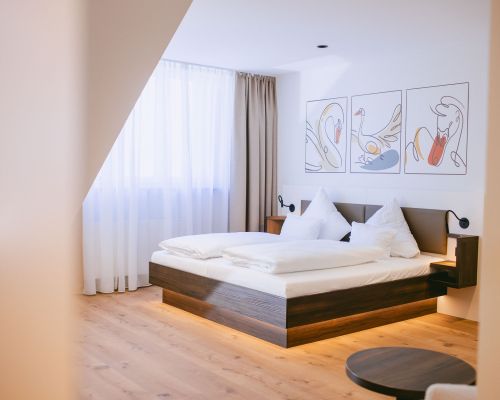 Bright comfort double room with a cozy double bed, warm wooden flooring and modern furnishings