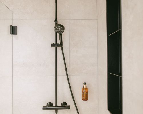 Elegant shower with black fittings, glass partition and timeless tile design