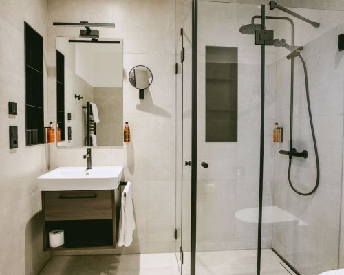 The modern bathroom offers a comfortable glass shower and a clean, high-quality design