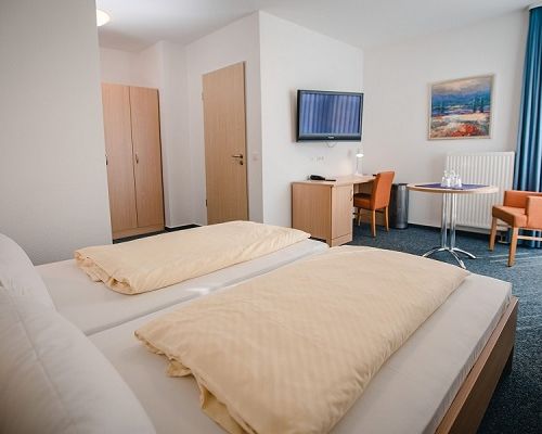 Double room with bed, desk, TV and balcony access