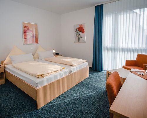 Bright standard double room with a cozy double bed, workspace and plenty of natural light.