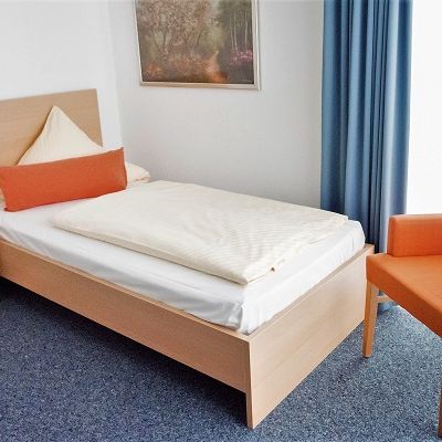 Helles Standard-Einzelzimmer mit Einzelbett und Sitzgelegenheit am Fenster