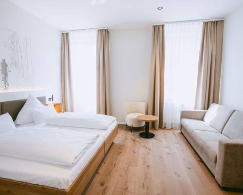 Bright double room with a double bed and cozy sofa