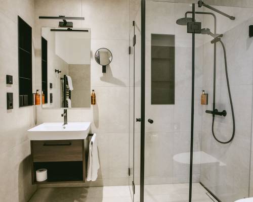 The modern bathroom offers a comfortable glass shower and a clean, high-quality design