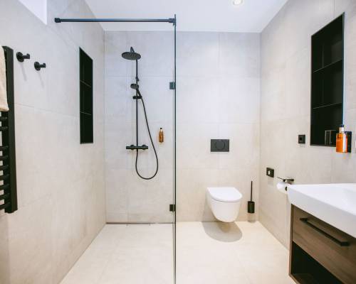 The bright bathroom offers a spacious shower, modern fittings and a clean design.