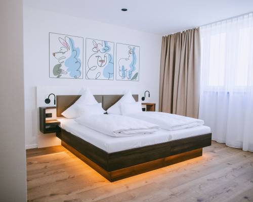 Bright comfort family room with a cozy double bed, warm wooden flooring and a welcoming atmosphere.