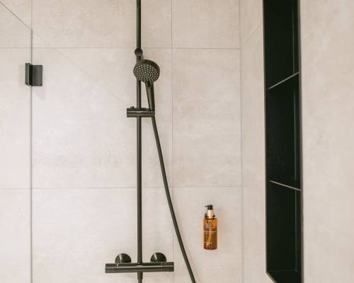 Elegant shower with black fittings, glass partition and timeless tile design